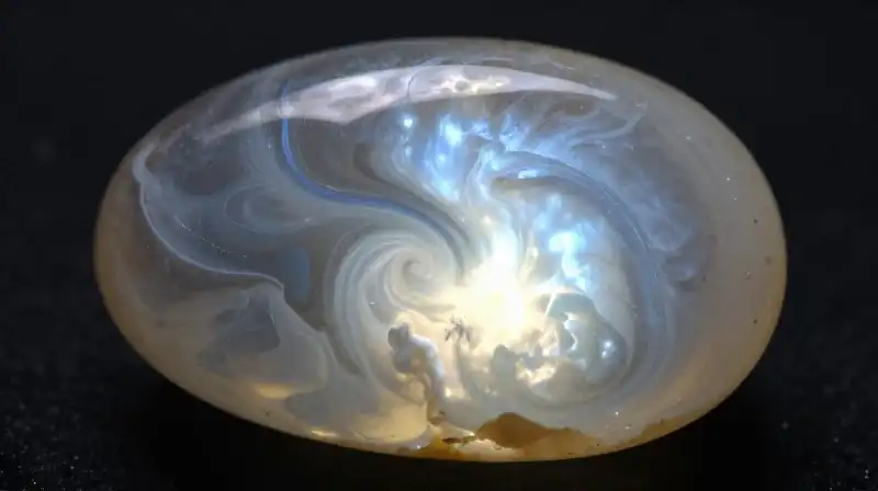 A glowing moonstone drifts in a swirling cosmic void