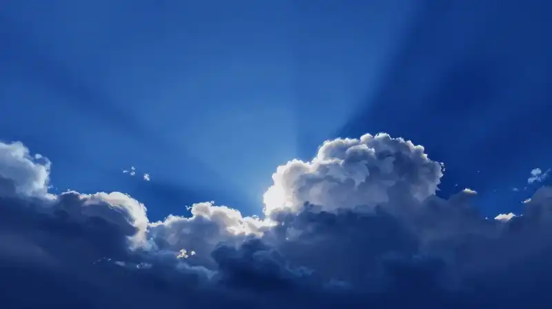 Vibrant light streams cut through an ethereal, deep blue sky